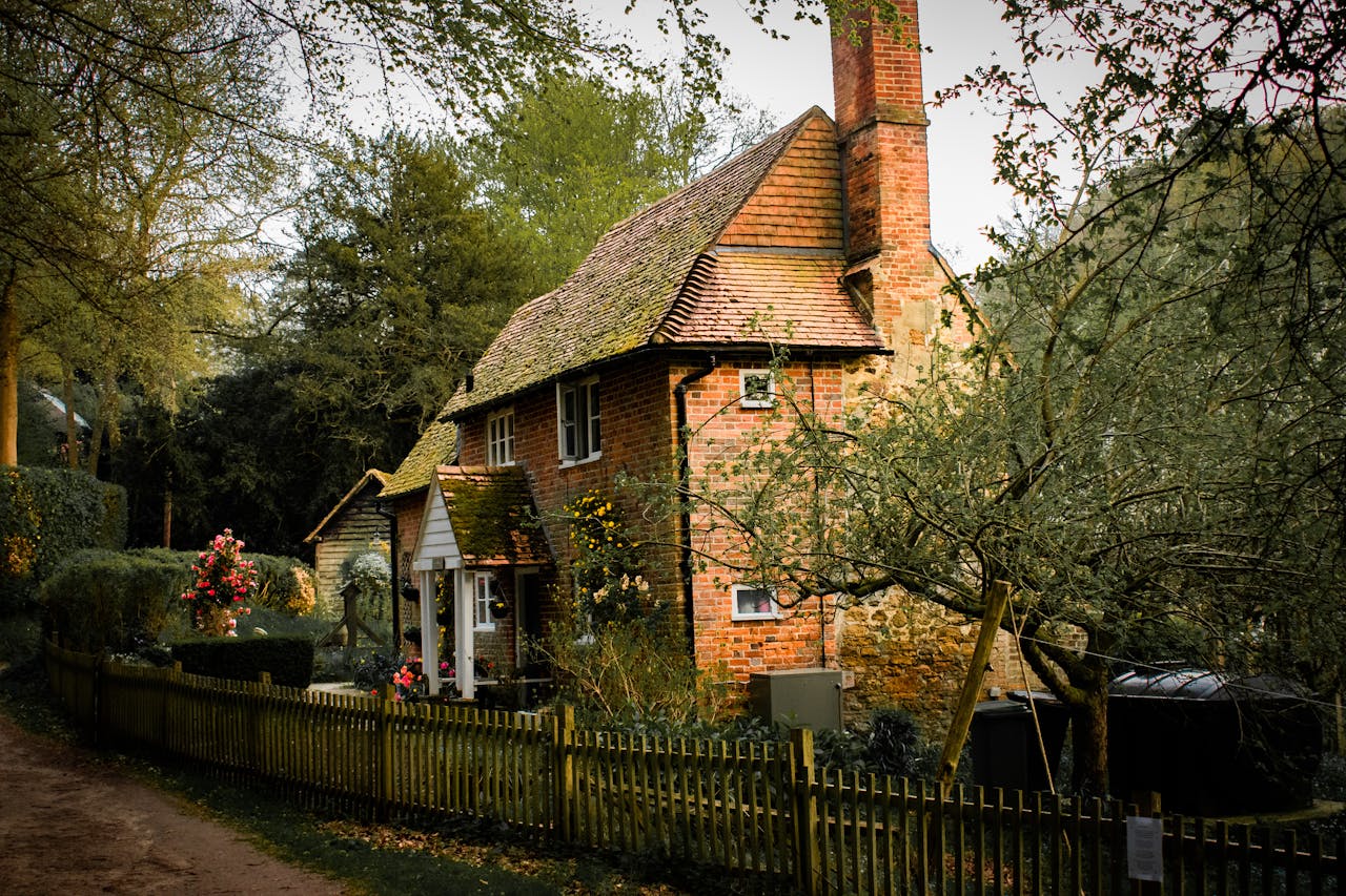 A picture of a cozy brick house surrounded by trees